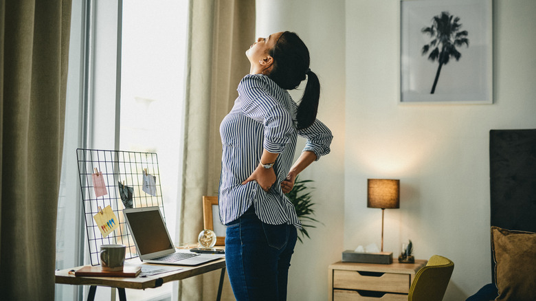 woman holding her lower back in pain