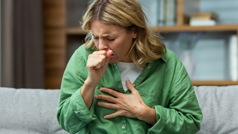 Woman coughing on couch