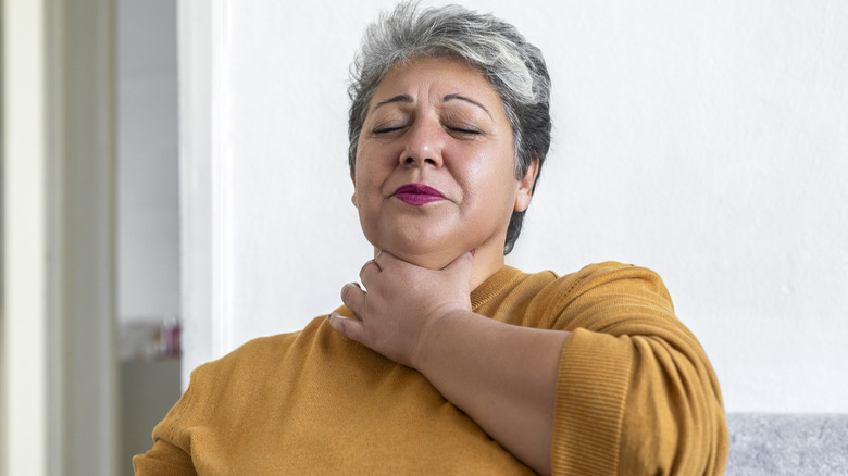 Woman clutching neck