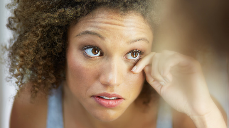 person checking their veiny eyes in a mirror