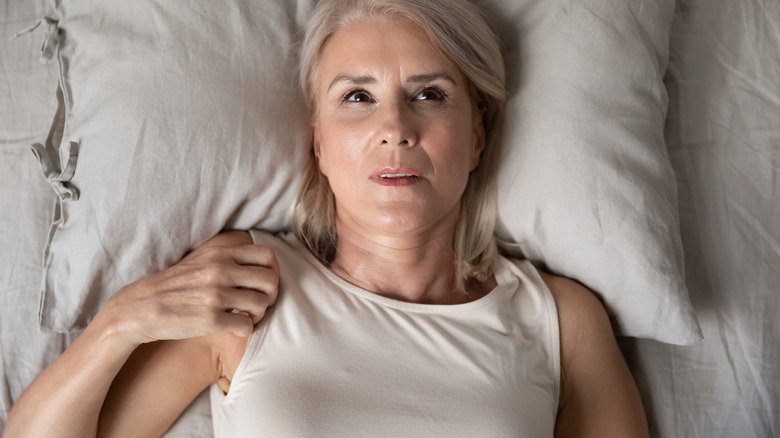 concerned woman lying in bed