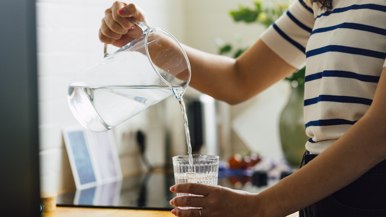 Hands pouring glass of water
