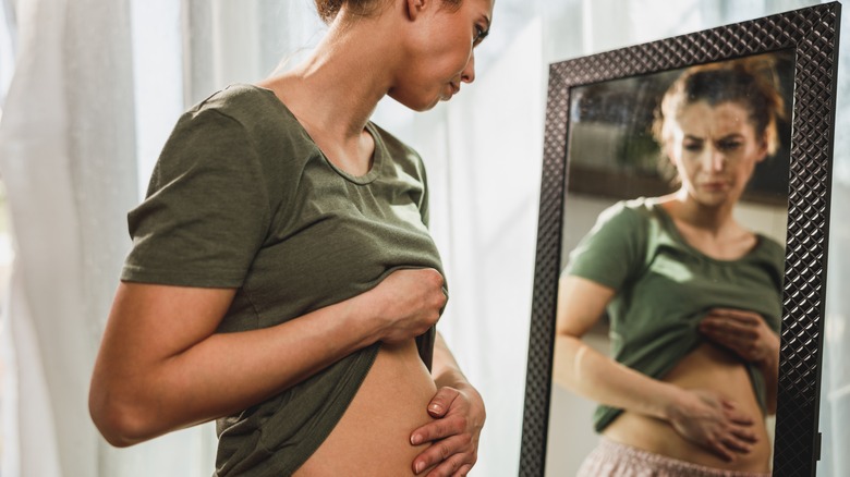 Woman holding bloated stomach