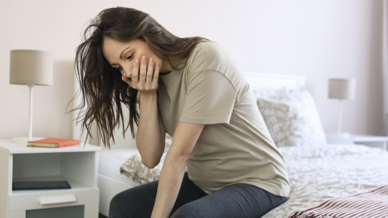 Sick woman sitting on bed