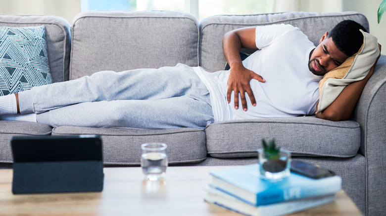 Man on couch with stomach ache