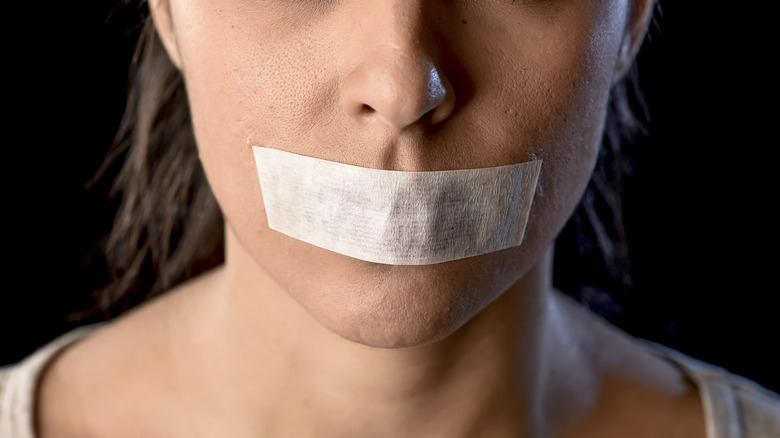 woman with mouth taped shut