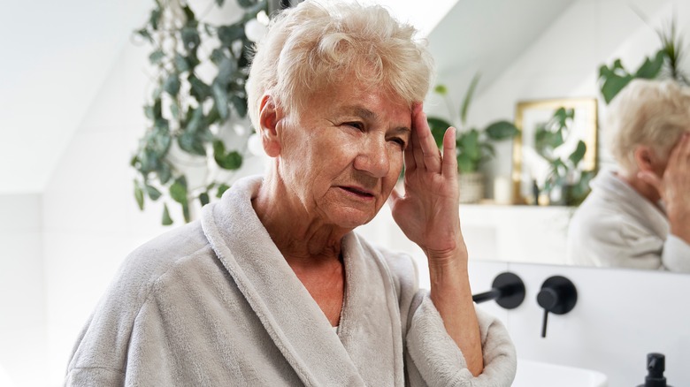 Woman with headache in bathroom