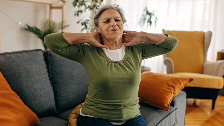 Woman holding neck in pain