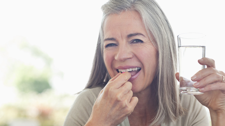 Smiling adult taking vitamin