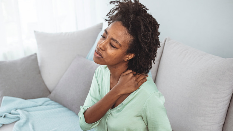 Woman rubbing painful shoulder