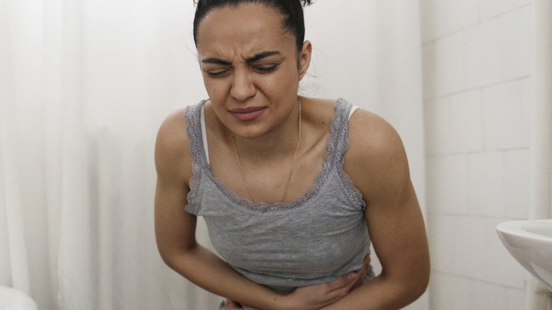 woman holding stomach in pain