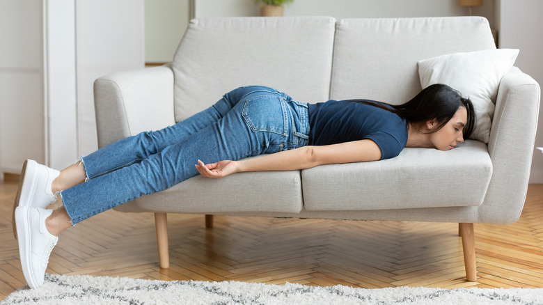 tired woman laying on couch