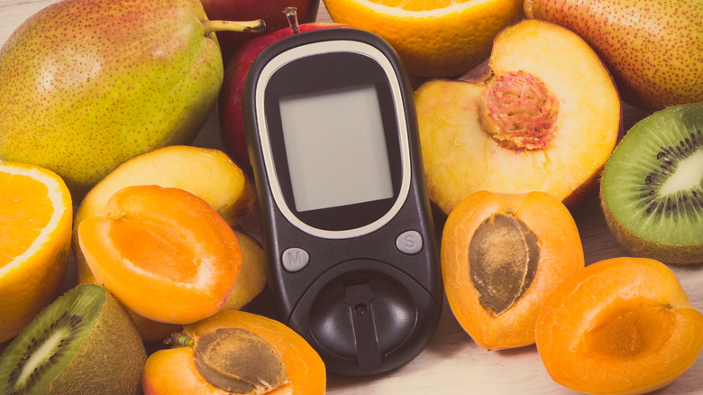Glucometer with vegetables and fruits in the background