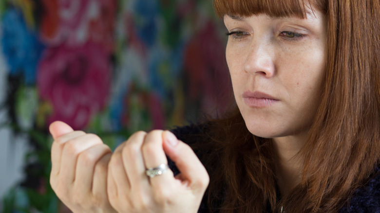 young woman examining her nails