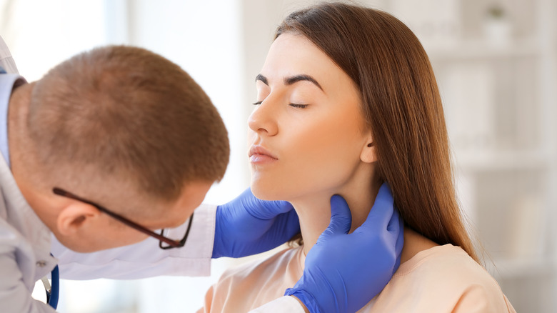 A doctor is examining a woman's throat