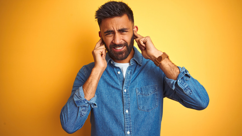 Man plugging his ears