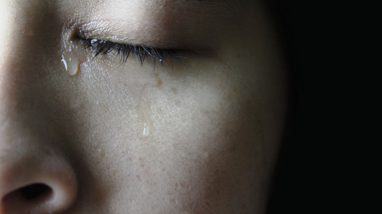 A close up of a woman crying with her eyes closed