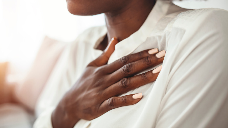 woman with hand on left side of chest