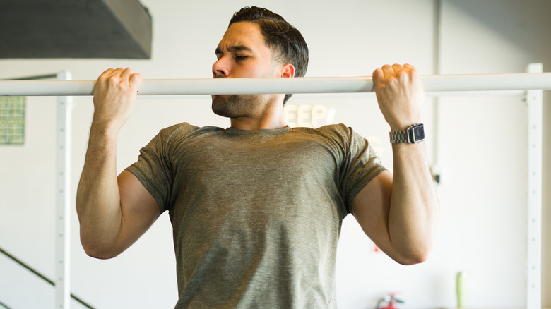 Guy doing pull-ups at the gym