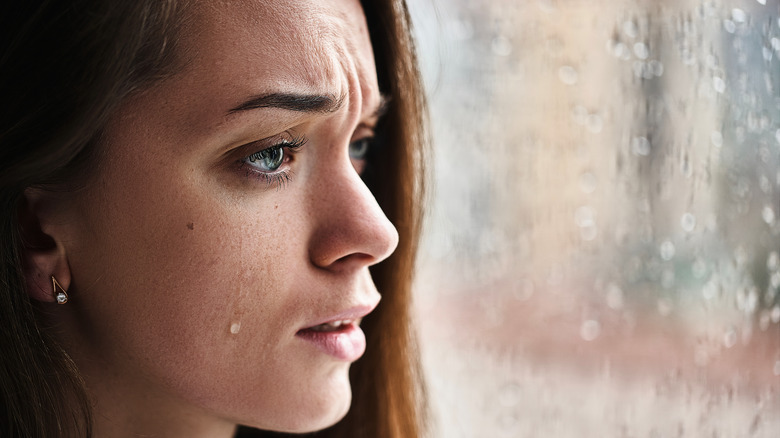 Woman crying and looking out window