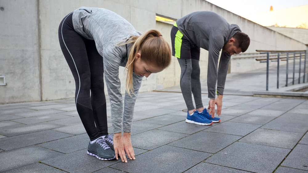 woman and man touching their toes