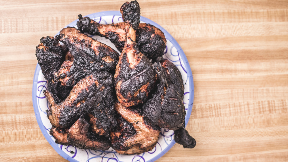 Burned chicken wings and legs on blue and white plate