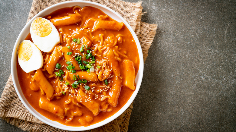 A bowl of spicy soup with a boiled egg