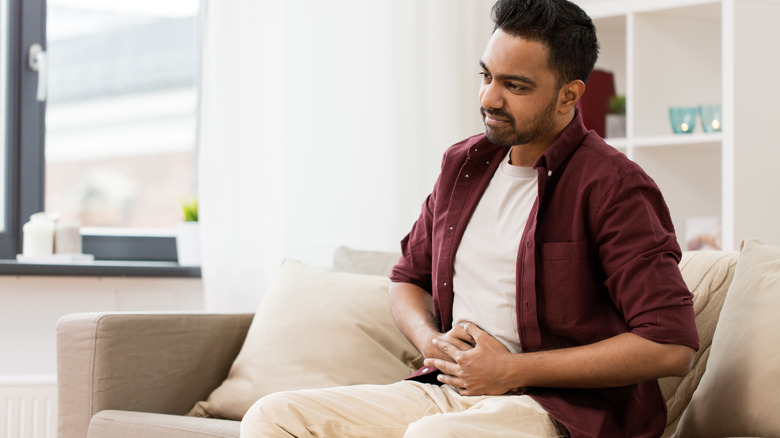 man holding belly from stomach ache