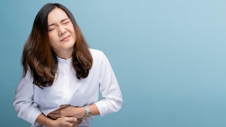 A nauseous woman holds her stomach