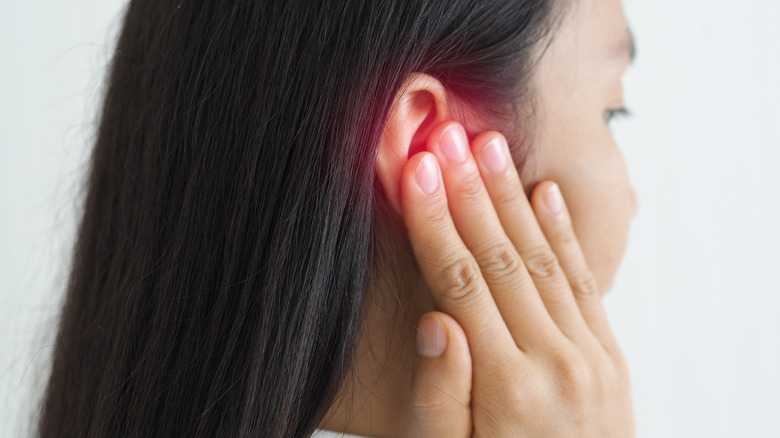 woman holding ear in pain