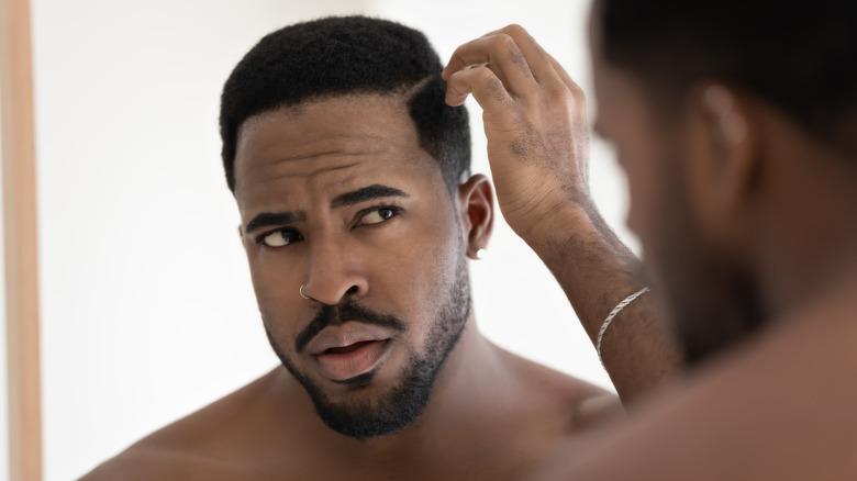 Man examining scalp