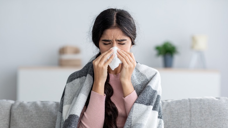 Woman blowing nose from allergy