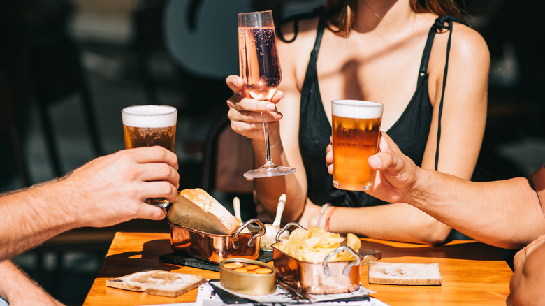 Three people holding drinks