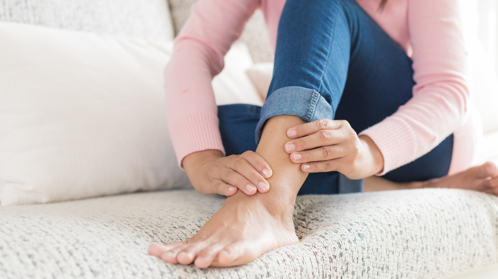 woman holding ankle