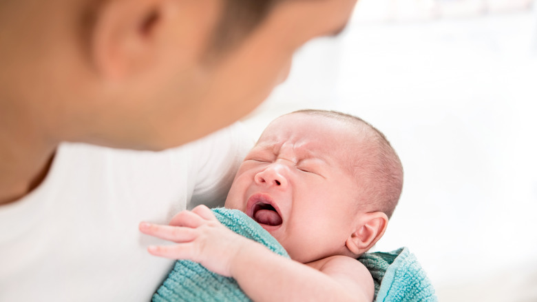 Man holding crying baby