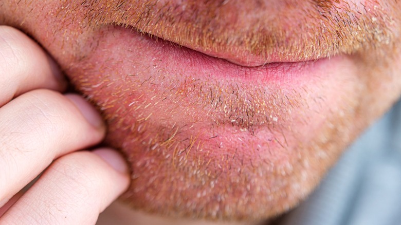 Close up on hand scratching beard