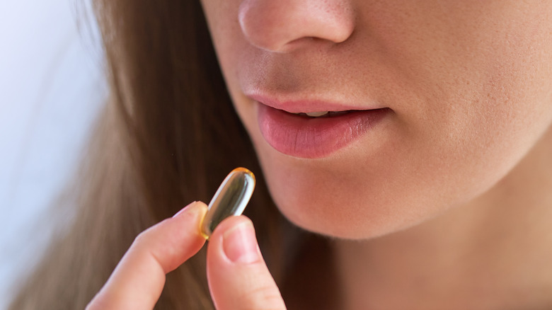 woman holds vitamin d supplement