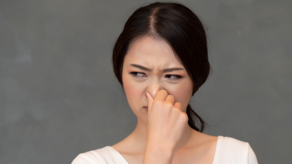 Asian women holding her nose due to an unpleasant stench 