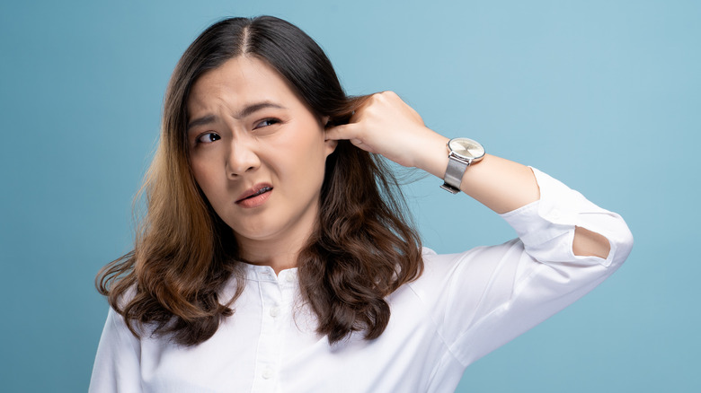 Woman putting finger into her ear