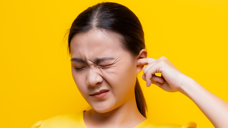 Woman sticking finger in her ear