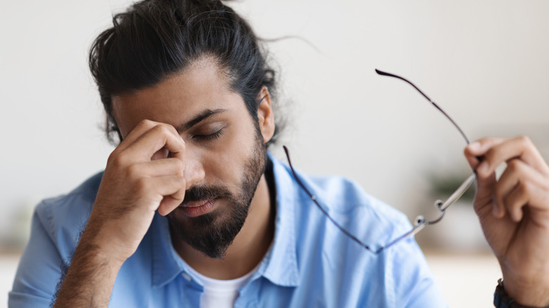 Man touching his eye