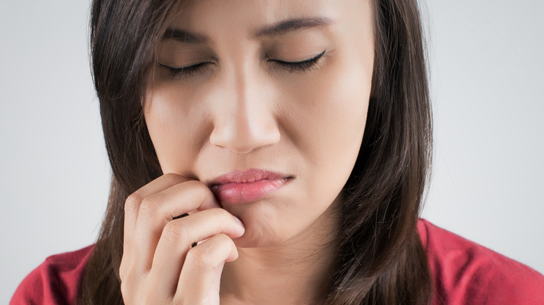 woman holding her numb face