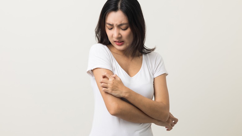 Woman scratching her arm