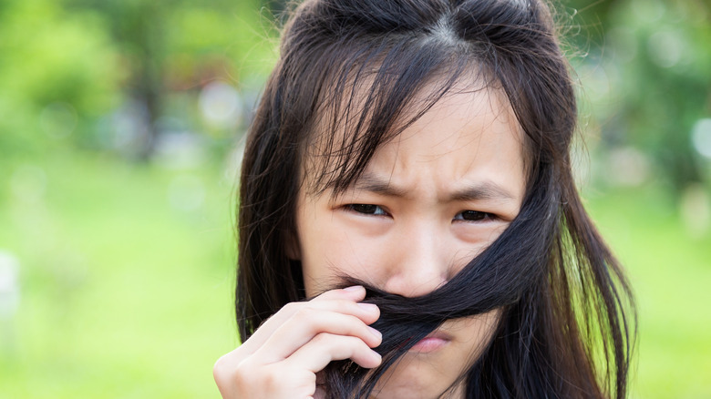 Asian girl smelling hair