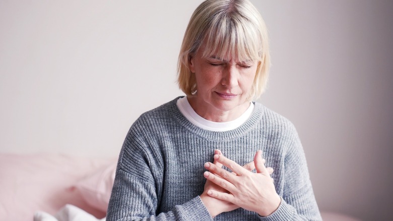 woman in distress with hand over heart