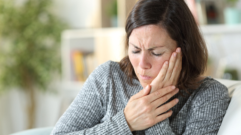 Woman holding her jaw in pain