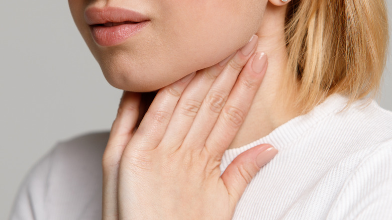 Close up of young woman feeling lymph nodes on her neck