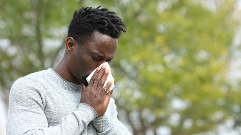 A man is blowing his nose