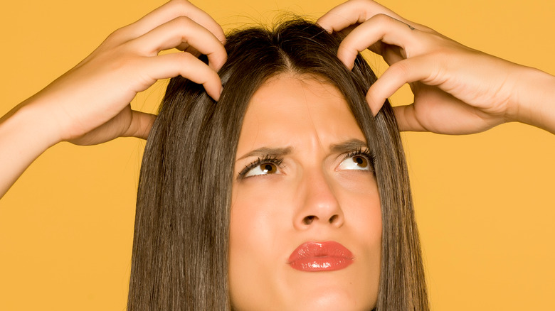 Woman scratching scalp