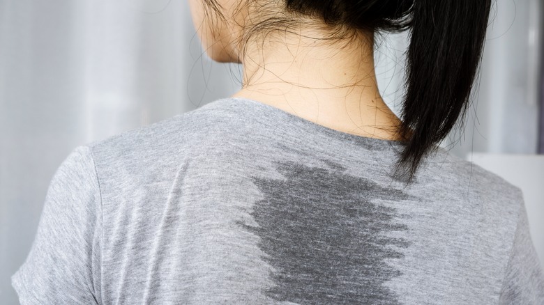 Woman with sweat on back of t-shirt